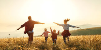 Happy family: mother, father, children son and daughter on sunset