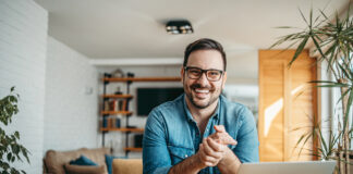 Portrait of a successful entrepreneur at cozy home office, smiling at camera.