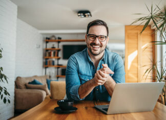 Portrait of a successful entrepreneur at cozy home office, smiling at camera.