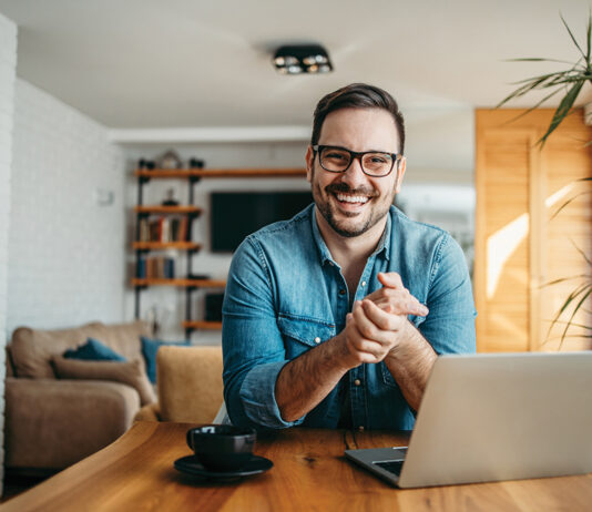 Portrait of a successful entrepreneur at cozy home office, smiling at camera.