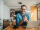 Portrait of a successful entrepreneur at cozy home office, smiling at camera.