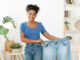 Happy Slim Black Girl Showing Old Jeans Standing At Home