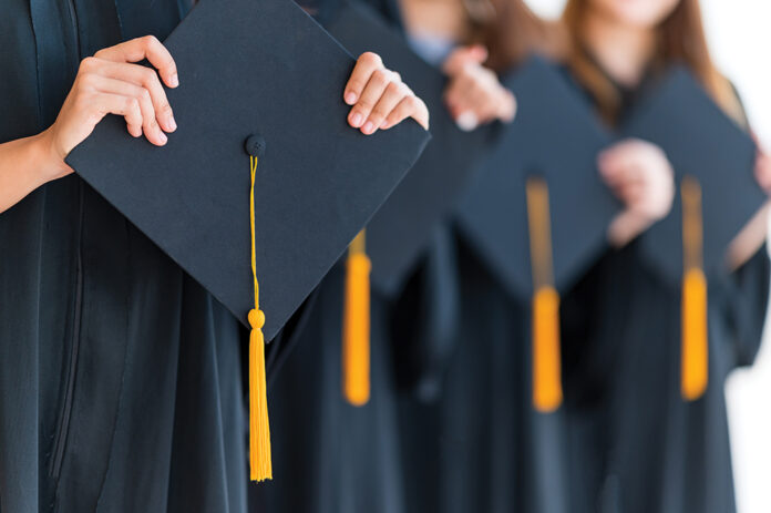 Close up group of graduates holding a hat At the graduation ceremony.