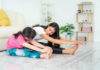 Asian Mother and daughter doing fitness exercises in living room at home to maintain physical and mental health and wellbeing get exercise into your daily routine while social distancing.