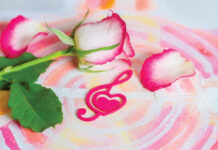 Rose with a decorative heart in the shape of a treble clef with pink felt on the background of painting. Valentine's day, mother's day congratulation.
