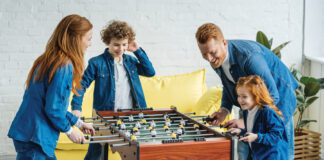 Happy family having fun while playing foosball