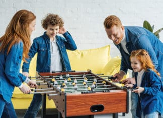 Family Room Fun Happy family having fun while playing foosball