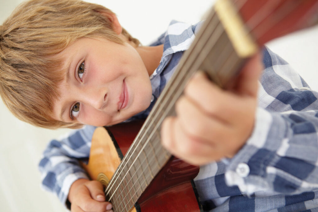 Young boy playing acoustic guitar