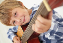 Young boy playing acoustic guitar