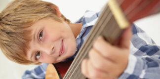 Young boy playing acoustic guitar