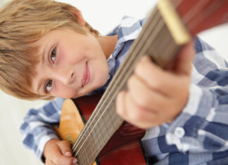 Young boy playing acoustic guitar