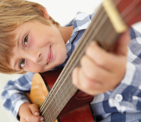 Young boy playing acoustic guitar