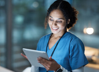 Nurse, medical tablet and black woman in hospital working late on telehealth, research or online consultation. Tech, healthcare or female physician with technology for wellness app in clinic at night