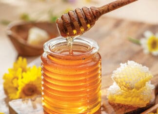 Hey Honey Natural organic honey in glass jar, honey dipper and honeycombs are near. Natural food background.